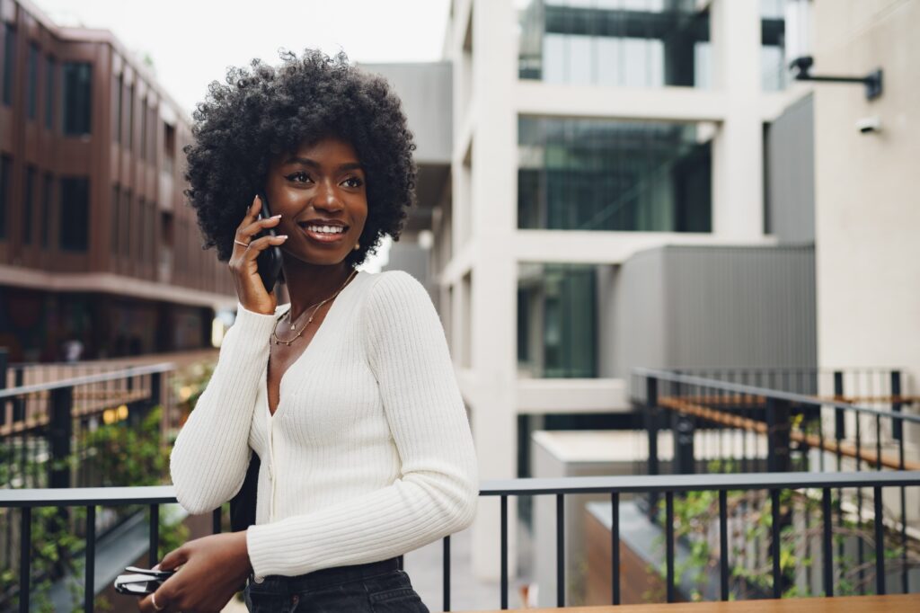Black afro woman talking on mobile phone in the city