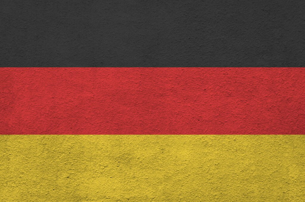 Germany flag depicted in bright paint colors on old relief plastering wall close up